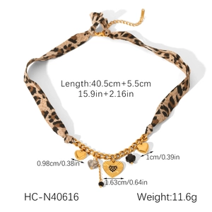 Detail view of leopard print ribbon necklace with gold heart pendants and size specs