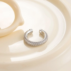 Manchette d'oreille en C argentée avec pavé de zircons sur un plateau en céramique