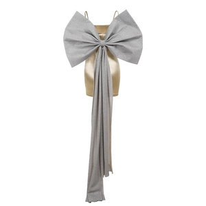 Détail d'une robe en satin doré avec un grand nœud pailleté argenté dans le dos
