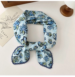 Detailed close-up of blue floral cotton linen scarf with elegant dark blue crochet lace edge