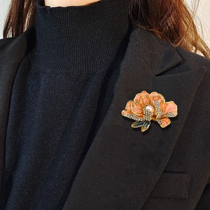 Pink enamel peony flower brooch with sparkling rhinestones and a center pearl on black blazer