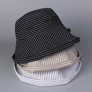 Vertical stack of striped cotton linen sun hats in black, beige, and white colors