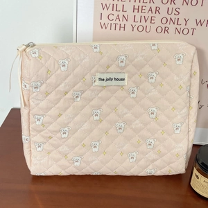 Close-up of pink quilted cotton pouch with rabbit pattern and brand woven label