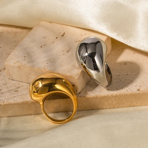 Anelli a goccia in oro 18K e argento su pietra con sfondo in seta elegante
