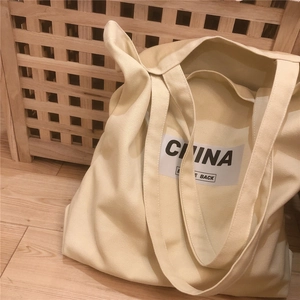 Détail de la texture en toile épaisse beige avec lettrage noir China sur le sac cabas