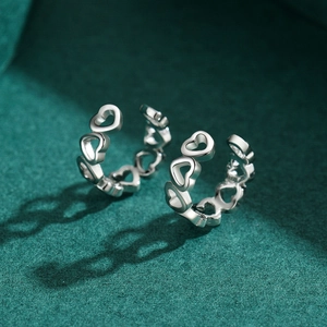 Minimalist S925 sterling silver heart-shaped hoop earrings on dark green background