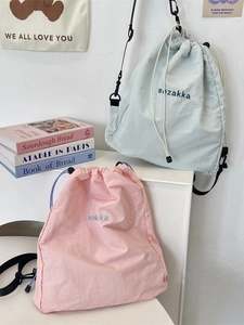 Lightweight nylon drawstring backpack set in soft pink and blue with embroidered logo