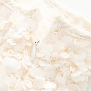 Macro detail of high-quality invisible zipper and cream sequins on the stylish dress
