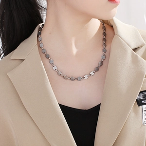 Close-up of a silver coffee bean link necklace worn on model for a minimalist aesthetic