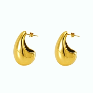 Macro shot of large polished gold water drop earrings with thick hollow C-shaped design