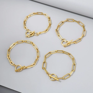 Quattro bracciali a catena dorati con chiusure OT a cuore e tonde eleganti