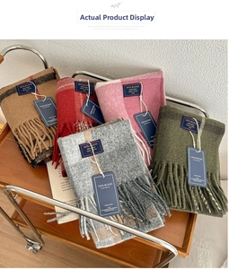 Classic British style check scarves in various colors with fringe on a vintage cart
