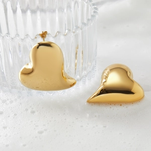 Vintage golden asymmetric heart earrings with polished finish displayed in creative bubbles
