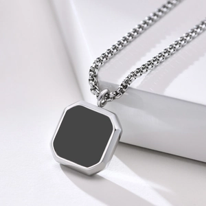 Macro view of silver box chain and square pendant with polished black inlay