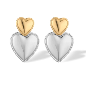 Detail of two-tone gold and silver heart earrings with a polished metallic finish