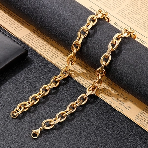 Nahaufnahme eines goldenen Edelstahl-Gliederarmbands mit Karabinerverschluss auf Zeitung