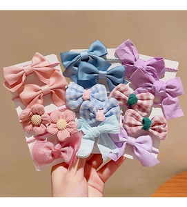 Detail of colorful bow elastic hair ties and clips set in pink blue and purple colors