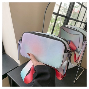 Detail of gradient crossbody camera bag showing colorful wide strap and textured finish