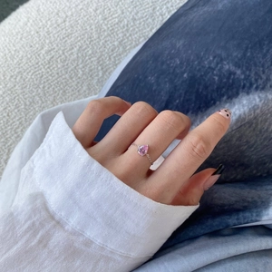Close-up of adjustable chain ring featuring a pink pear-cut zircon on model's finger