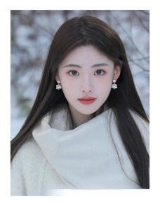 Detail of 14k gold plated snowflake drop earring with zircon on model in winter setting
