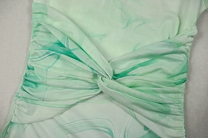 Detail of light green marble print fabric with elegant twisted knot and ruched textures