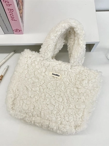 White plush lamb fleece handbag with Sozakka label on a white table background