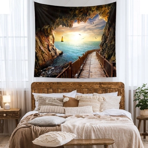 Détail d'une tapisserie bohème de coucher de soleil sur mer au-dessus d'un lit en bois