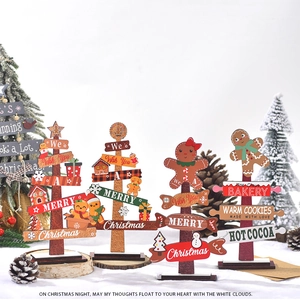 Detailed view of four wooden Christmas tabletop ornaments including gingerbread shop
