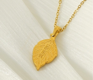 Détail macro du pendentif feuille en acier plaqué or 18 carats avec textures de veines