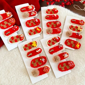 Détail de pinces à cheveux festives en peluche rouge avec broderie du Nouvel An chinois