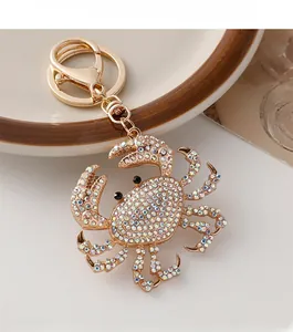 Close-up of a golden metal crab keychain encrusted with colorful AB rhinestones and lobster clasp