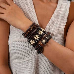 Close-up of bohemian layered wood bead bracelet with floral accents on wrist