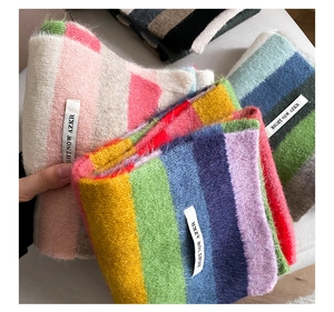 Close-up of soft rainbow mohair knit scarf with colorful stripes and branded tag
