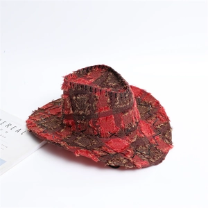 Detail of red-brown checkered cowboy hat with distressed edges and stitching