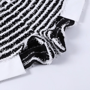 Détail macro du tissu en maille rayé noir et blanc avec bordure à franges texturées