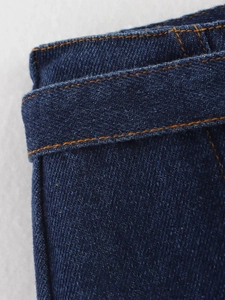 Gros plan détaillé sur le denim bleu foncé avec des coutures orange et texture du tissu
