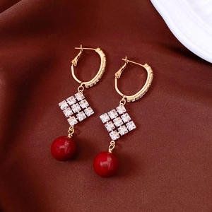 Vue détaillée des boucles d'oreilles en perles plaquées or 18 carats avec accents rouges