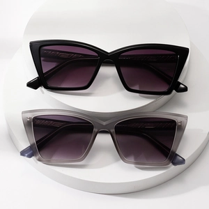 Classic cat-eye sunglasses in black and transparent grey on white geometric stands