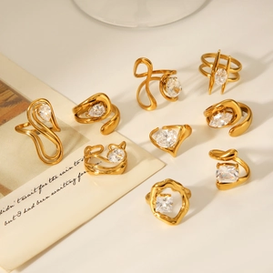 Detail of gold-plated titanium steel rings set with sparkling pear and heart shaped zircons