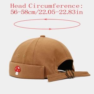 Detail of adjustable metal buckle and mushroom embroidery on the brown docker hat