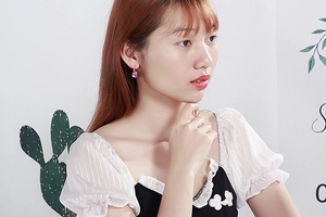 Close-up of a woman wearing a purple square-cut crystal earring in stainless steel