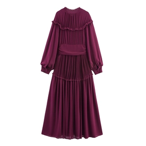 Détail montrant l'encolure à volants et le tissu en mousseline plissée d'une robe magenta