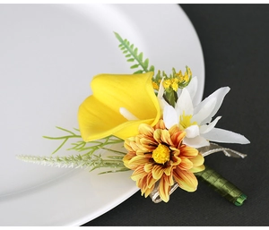 Macro detail of calla lily boutonniere with yellow petals and green ribbon on white plate