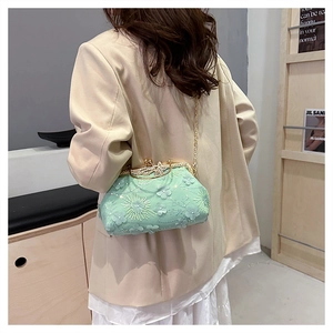Detailed close-up of 3D floral embroidery and sequins on the mint green shell bag