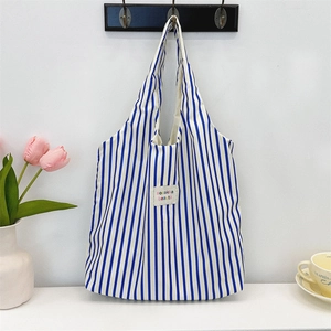 Gros plan détaillé du sac cabas à rayures bleues et blanches avec étiquette de marque