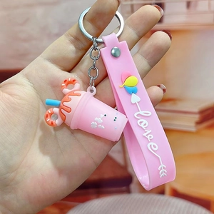 Pink cartoon milk tea cup keychain with heart details and a silicone Love wrist strap