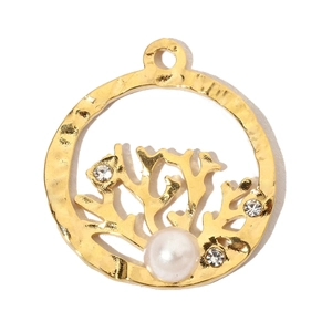 Macro detail of golden coral pendant with pearl and crystal accents on white background