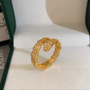 Macro shot of gold snake ring featuring detailed scales and sparkling white zircon stones