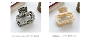 Detail view of small square acetate hair claws in leopard print and marble white