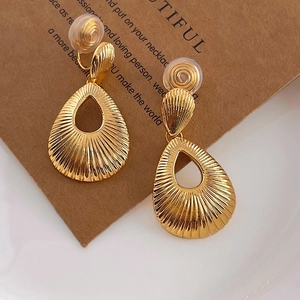 Golden teardrop textured clip-on earrings with soft silicone pads on vintage card